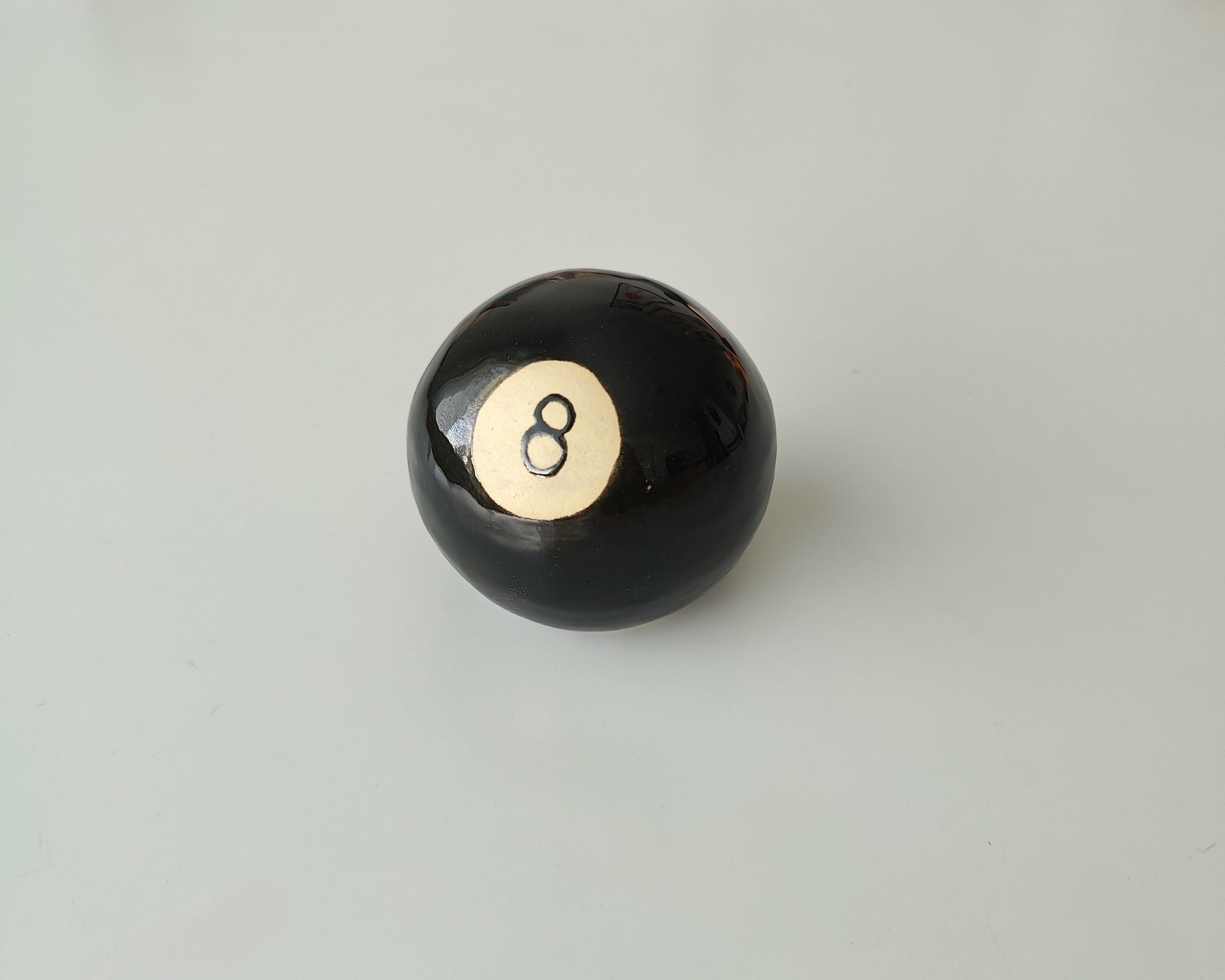 Keraaminen veistos biljardin 8-pallosta.